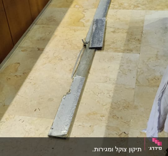 שני קורות מתכת מונחות על רצפה במטבח